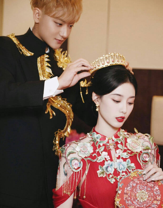 people-man-placing-crown-on-woman's-head-woman-wearing-red-dress-and-crown-wedding-attire