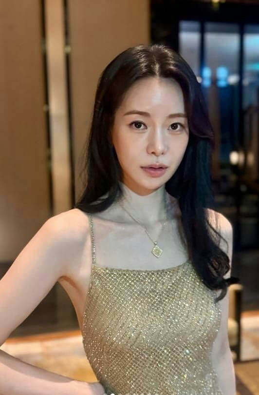 people-woman-A-long dark hair-B-gold sparkly dress-C-delicate necklace