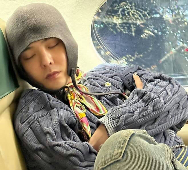 people-1-man-A-sleeping-A-aviator-hat-A-cable-knit-sweater-A-scarf-A-window-view