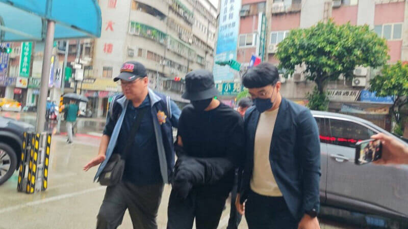 people-three men-A-escort-A-face obscured-B-rainy street-C-crowd attention