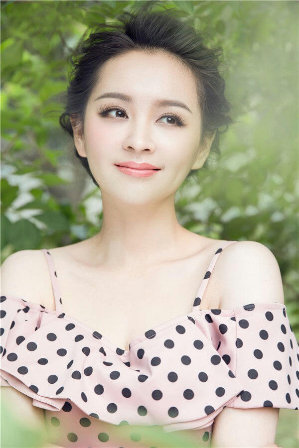 people-Woman-A-outdoor setting-A-polka dot top-A-natural light-A-looking away