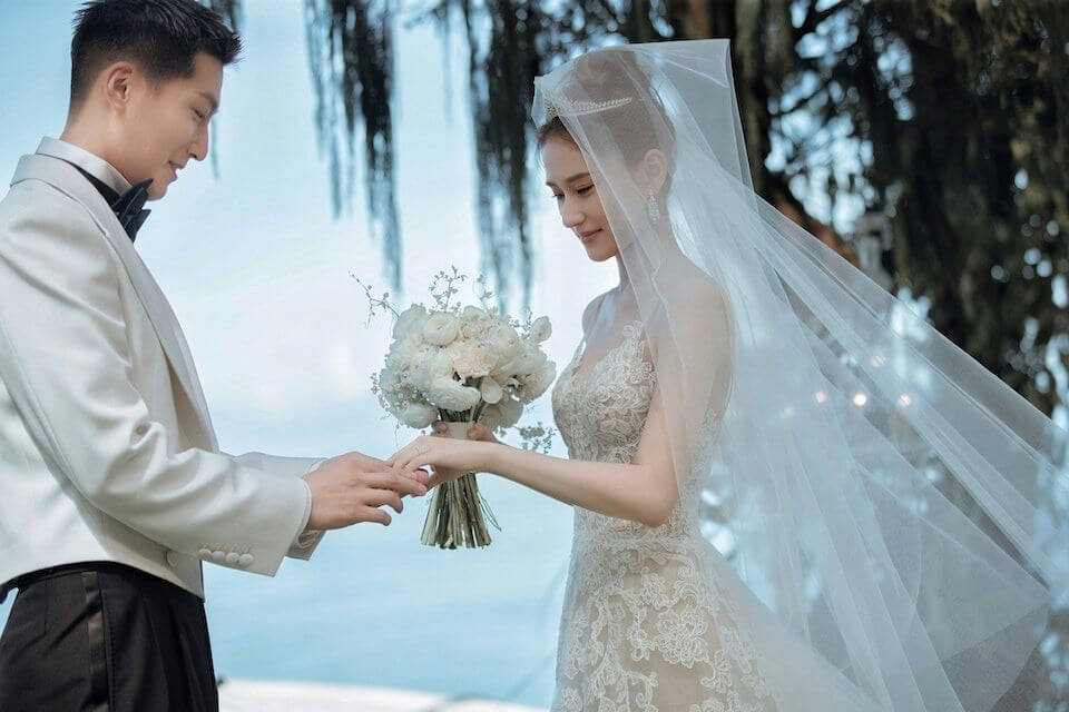 people-A-bride-A-groom-A-wedding-A-holding hands-A-bouquet-A-lace dress-A-veil-A-tuxedo