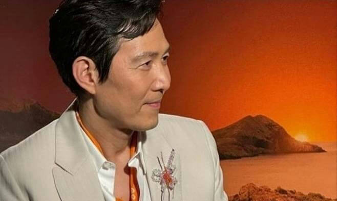 people-Lee Jung-jae-A-close-up-A-orange-sunset-background-A-white-suit-A-brooch