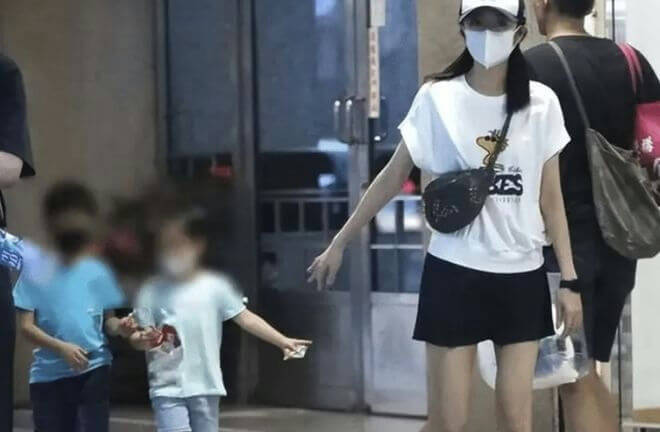 people-woman-wearing-white-t-shirt-and-black-skirt-A-two-children-faces-blurred-A-man-walking-behind-woman-B-woman-wearing-face-mask-and-baseball-cap-C