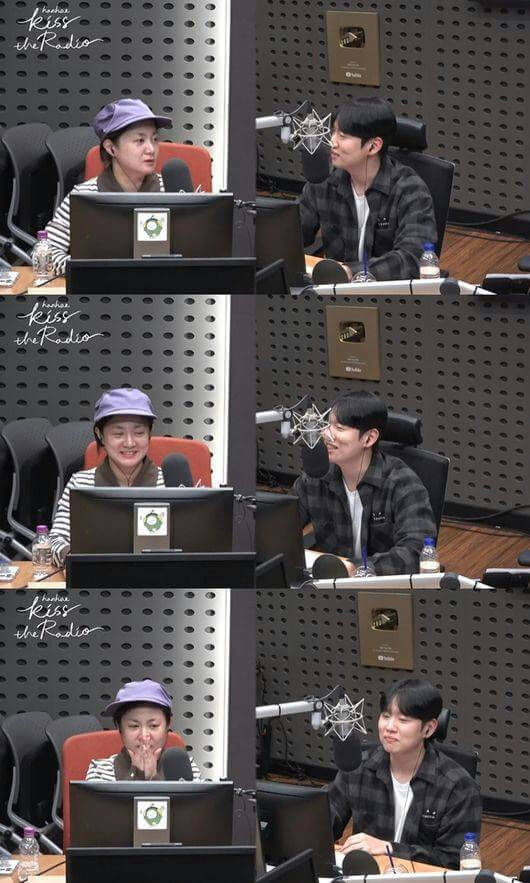 people-two people-A-radio studio-A-guest and host-A-Kiss the Radio logo-B-man in plaid shirt-B-woman in purple cap-C-conversation/interview-C-applause/reaction