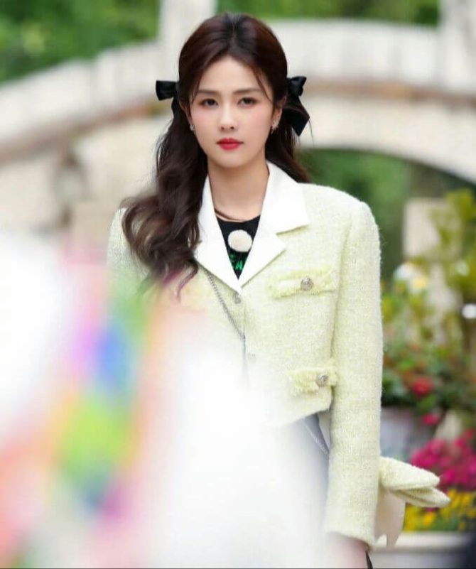 people-woman-A-black bows in hair-B-light yellow tweed jacket-C-outdoor setting