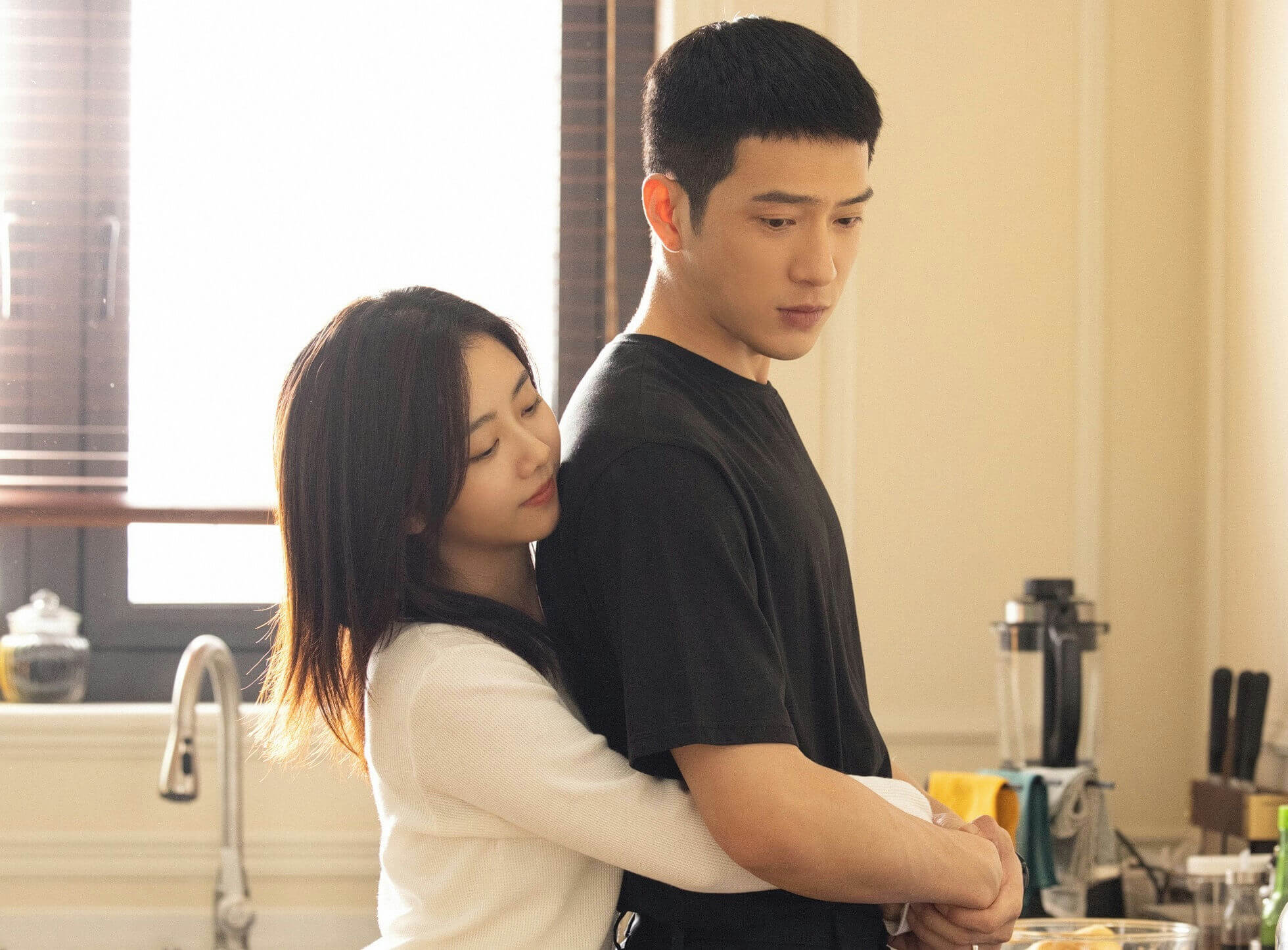people-woman embracing man-A-intimate-A-kitchen setting-A-soft lighting-A-candid moment