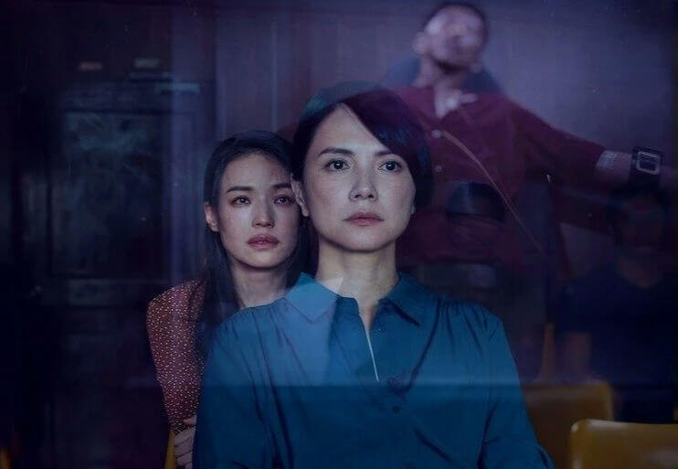 people-Two women in foreground-A Distressed man in background-A Dark, moody lighting-A Mystery/Thriller theme