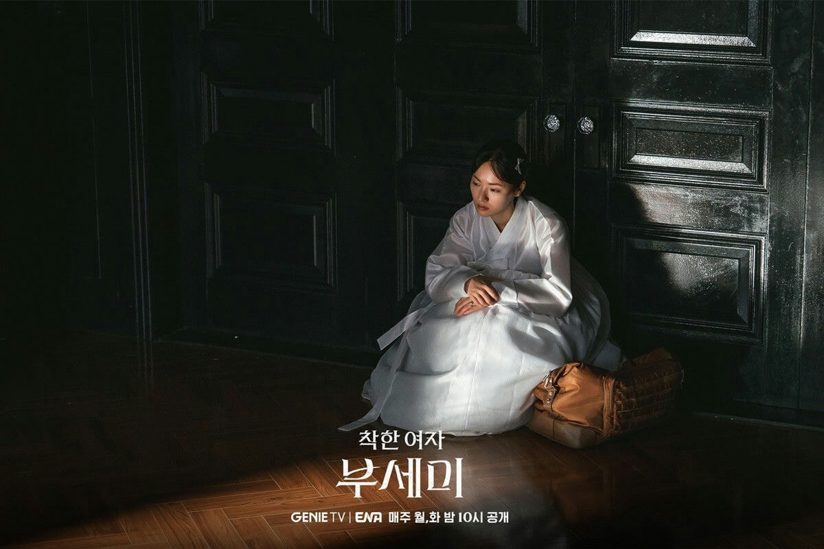 people-A-woman in white Hanbok-A-sitting on floor-B-in dark room-C-with brown bag
