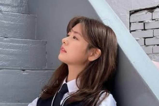 people-woman-brown hair-school uniform-looking up-leaning against wall