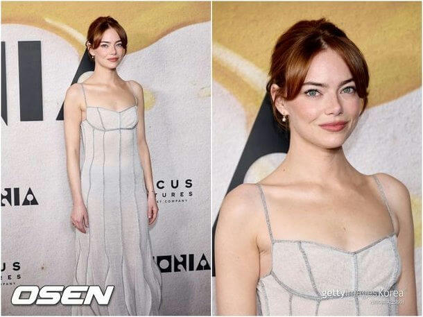 people-Emma Stone-reddish brown hair with bangs-light gray sheer slip dress with visible stitching-light makeup with pink lips-pearl drop earrings