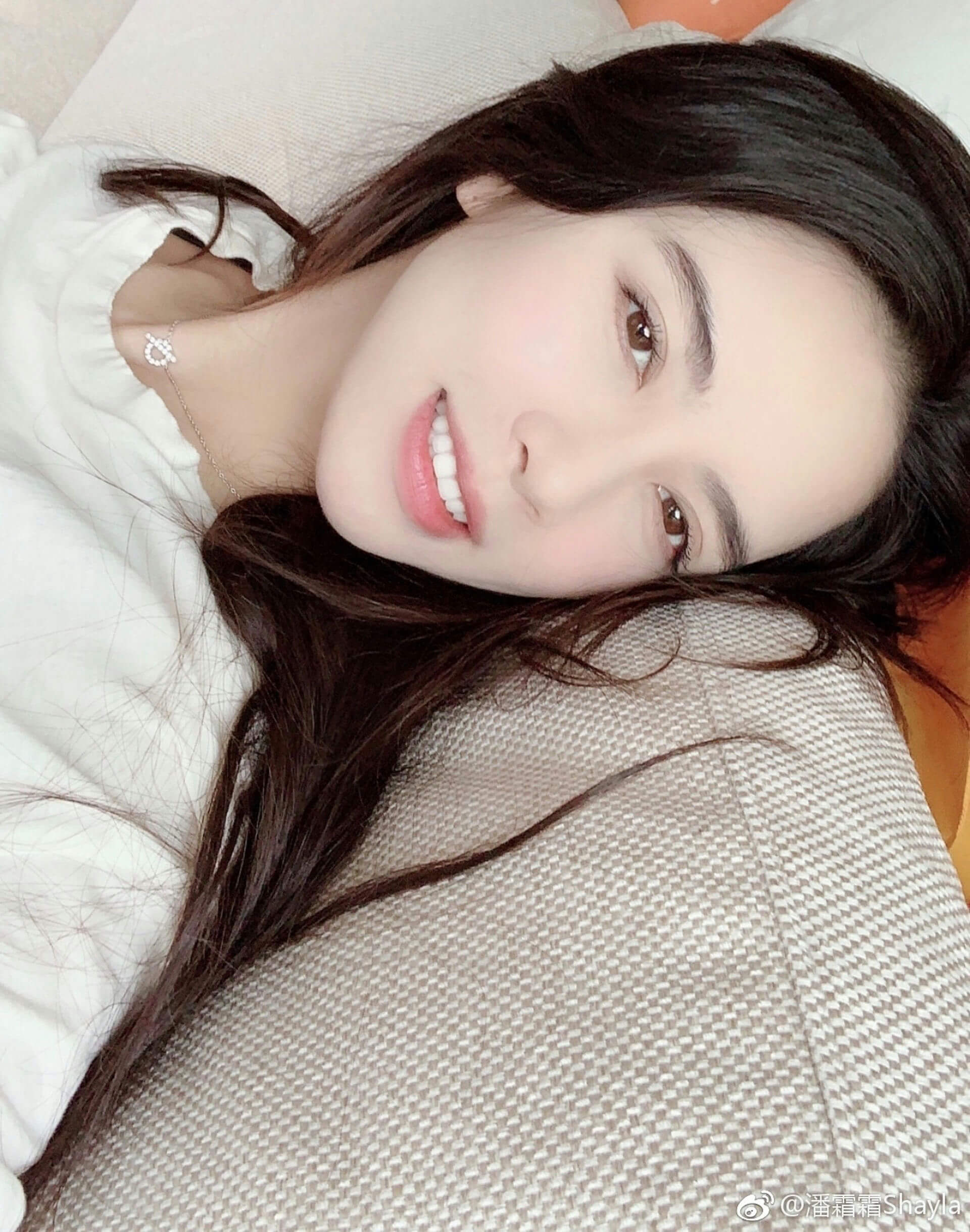 people-woman-A-lying down-A-smiling-A-dark hair-A-white top