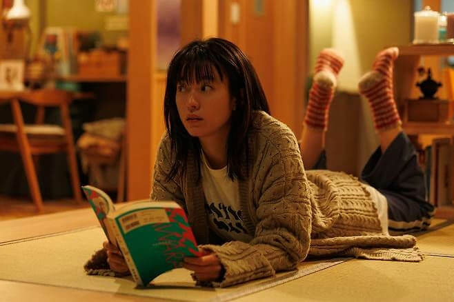 people-A-woman-A-reading-A-lying on floor-B-striped socks-B-cozy sweater-C-indoor setting