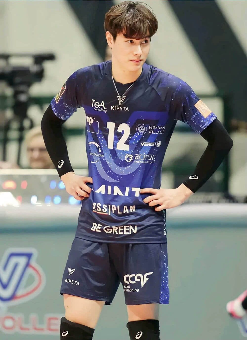 people-Volleyball player-A-male-A-blue jersey with number 12-B-hands on hips-C-indoor court setting