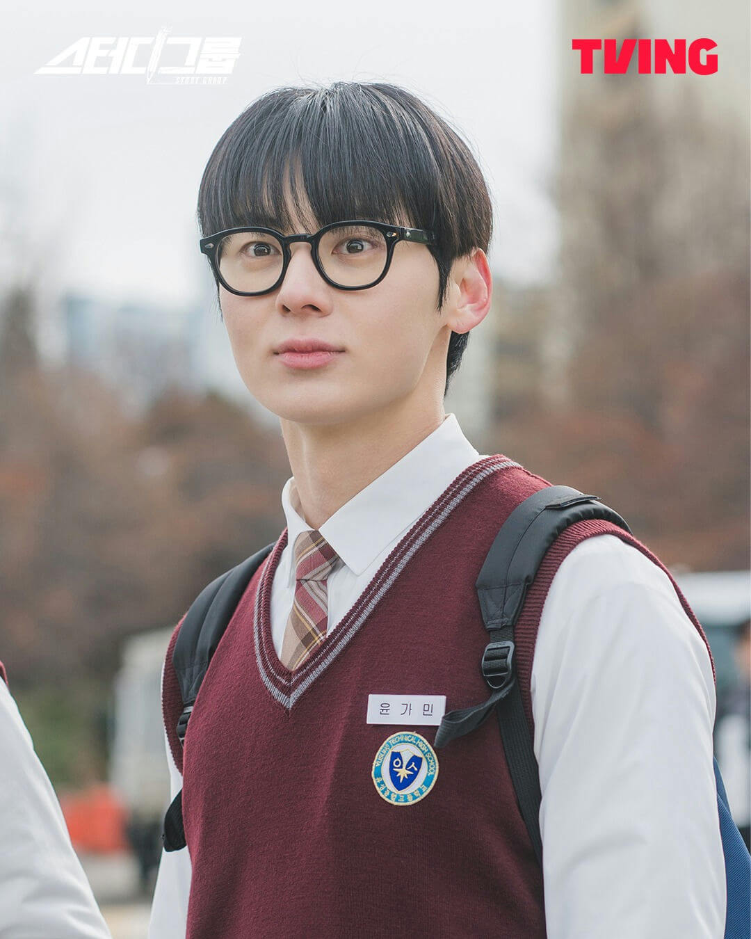 people-A-male student-A-black hair-A-glasses-A-school uniform-B-maroon vest-B-white shirt-B-necktie-C-looking forward