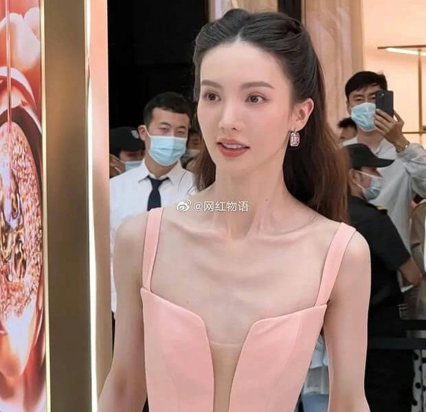 people-woman in pink dress-A-thin collarbones-B-crowd in background-C-social media watermark