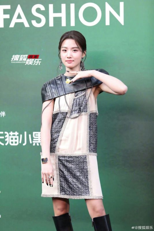 people-A-young woman-A-fashion event-A-patchwork dress-A-leather epaulette-A-long black boots