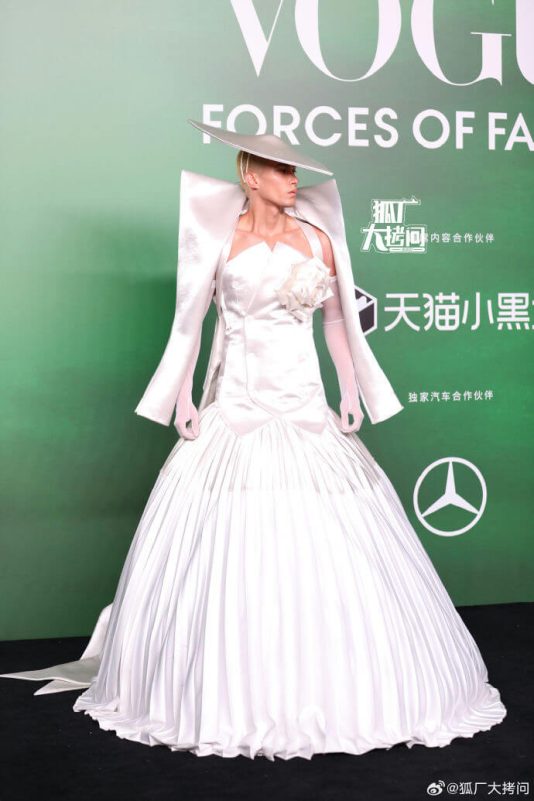 people-A-person in white gown-A-wide brim hat-B-pleated skirt-C-green background