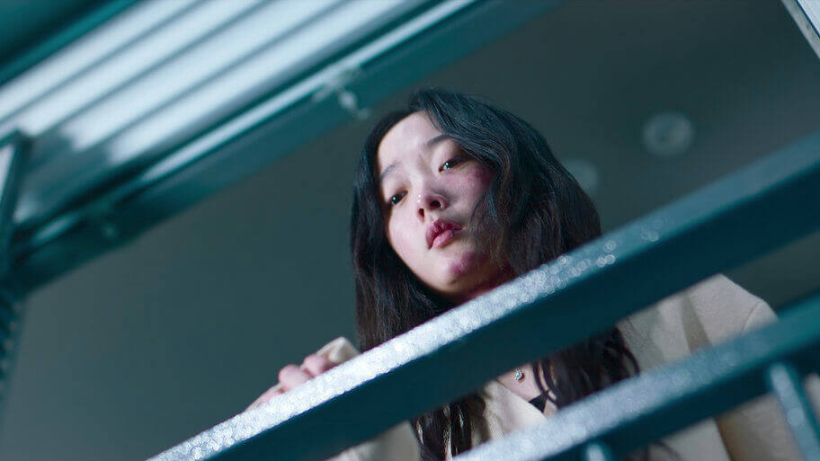people-A-young woman-A-looking down-A-red marks on face-A-dark hair-A-blue railing-A-dramatic lighting