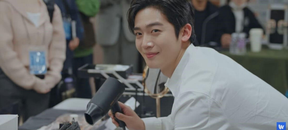 people-young Asian man-A-white collared shirt-B-holding black hairdryer-C-smiling and looking at camera