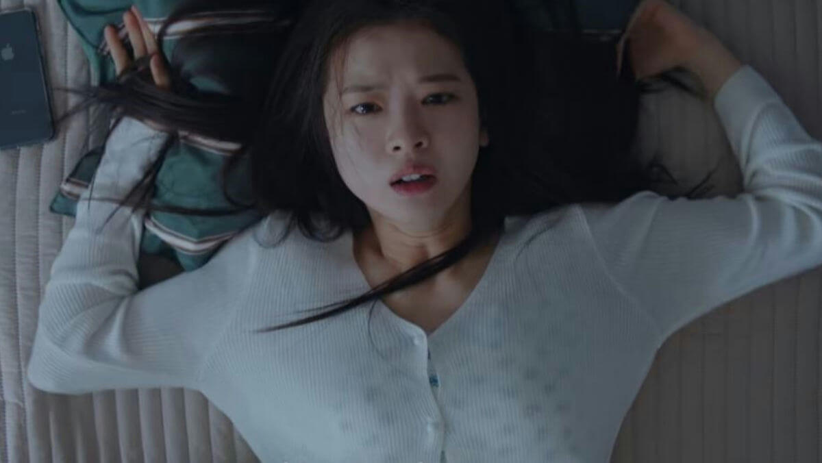 people-young woman-lying down-surprised expression-white cardigan-dark hair-apple phone
