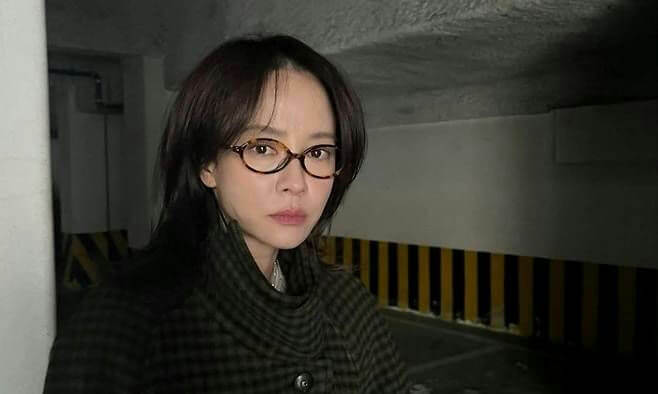 people-Korean actress Song Ji Hyo-A-dark shoulder-length hair-A-tortoiseshell oval glasses-B-dark plaid coat with high collar-C-dimly lit underground parking garage setting