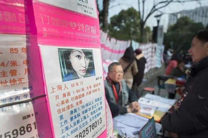 people-A-matchmaking stall-A-Chinese characters-B-outdoor setting-C-pink flyers