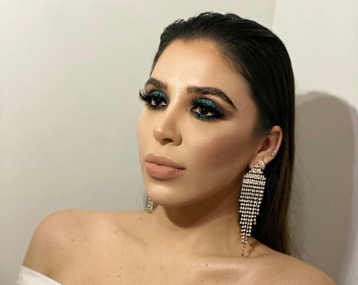 people-A-woman-A-dark hair-A-heavy makeup-B-emerald eyeshadow-C-dangling earrings