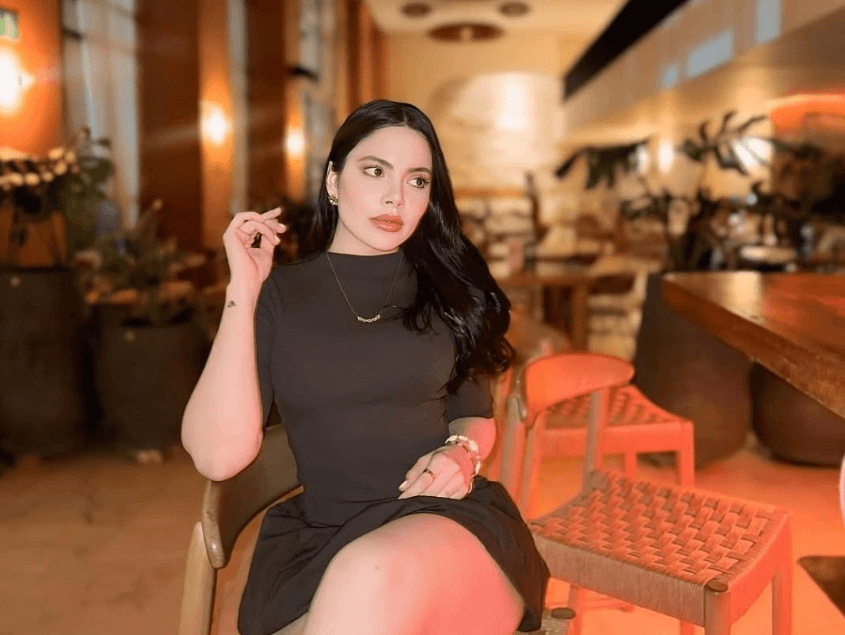 people-1-woman-A-dark hair-A-black dress-A-restaurant setting