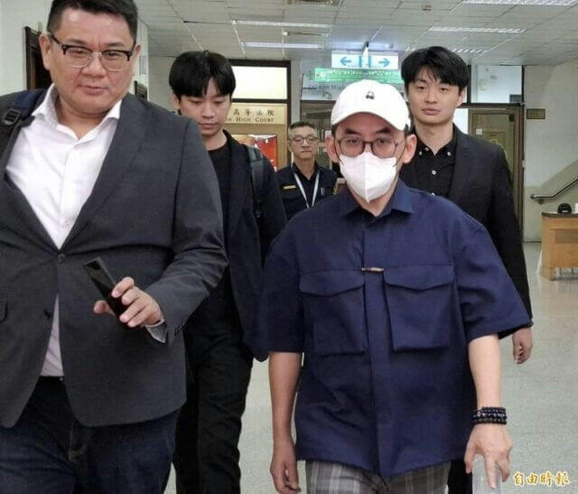 people-four men-A-walking indoors-A-wearing face mask-A-court building background-B-professional attire-B-casual attire-C-holding phone-C-holding papers