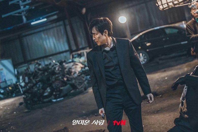 people-One man in a black suit-A-intense gaze-B-dark setting-C-trash pile