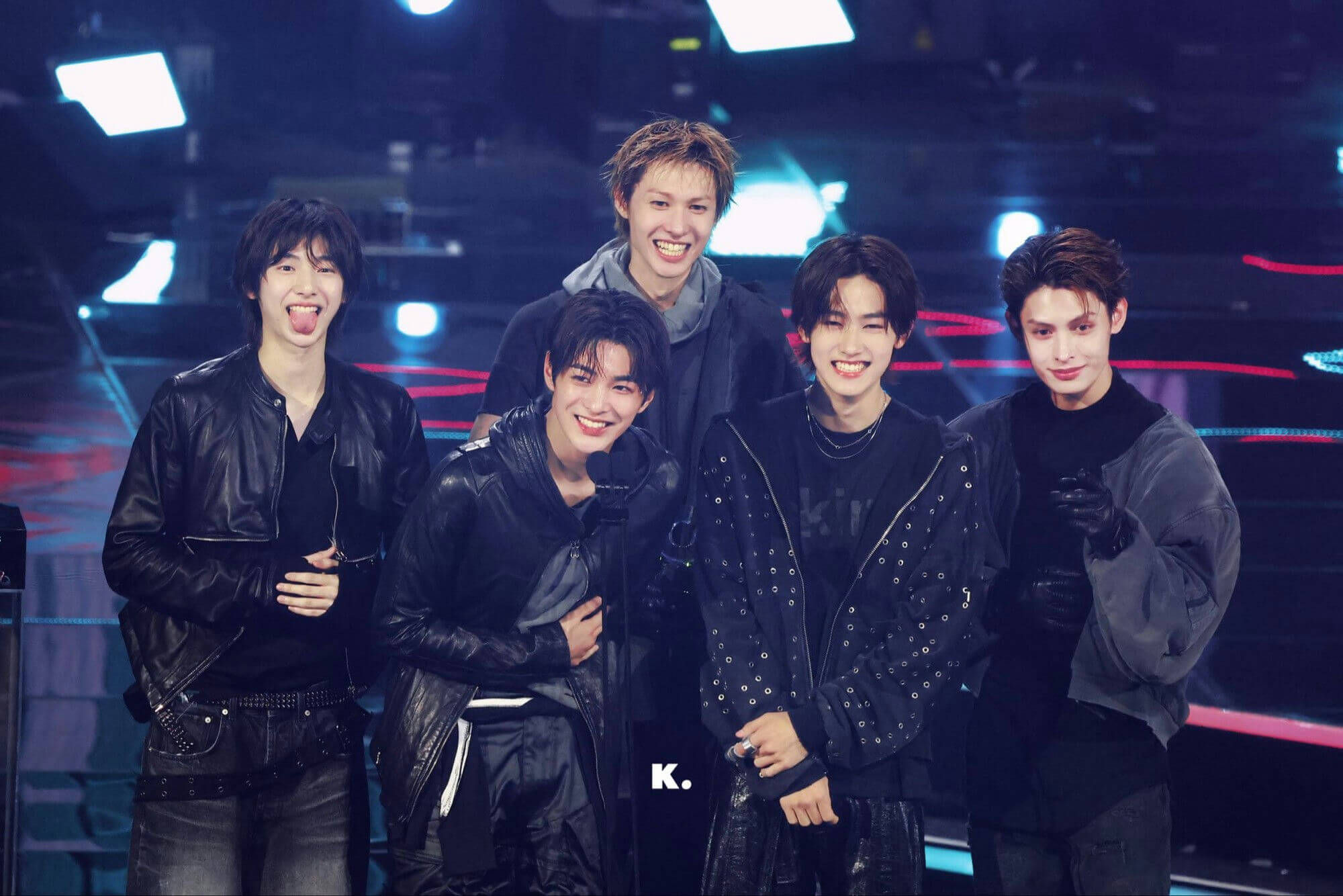 people-five young men-A-stage lighting-A-black leather jackets-A-smiling-A-casual pose