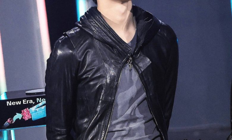 people-One young man-A-East Asian descent-A-dark hair-A-wearing black leather jacket-A-looking up and to the right-A-on stage or set-A-stage lighting present