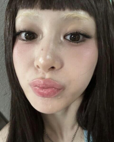 people-woman-A-bleached eyebrows-A-dark hair-A-bangs-A-glossy lips-A-close-up selfie