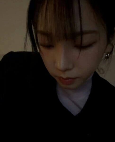 people-woman-looking down-dark hair-bangs-black top-indoors