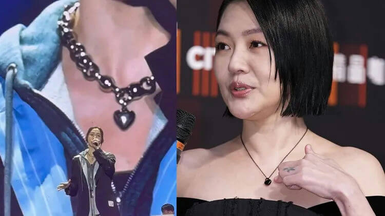 people-female singer on stage-necklace with black heart pendant-female celebrity at event-necklace with black heart pendant