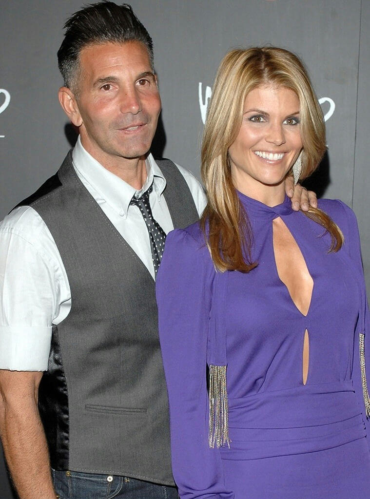 people-man and woman-standing side-by-side-man in grey vest and white shirt-woman in purple dress-smiling-posing for photo