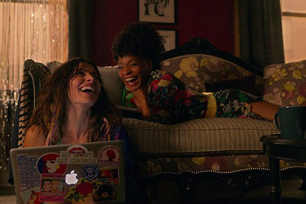 people-two women-A-laughing-A-laptop-B-couch-C