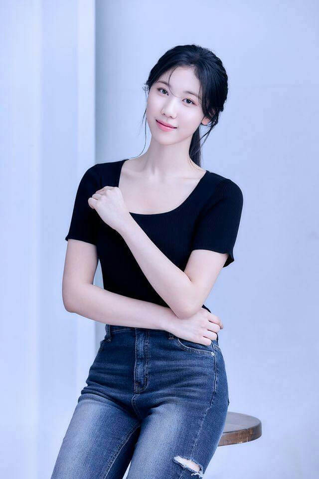 people-woman-A-black top-A-blue jeans-A-posing-B-dark hair-B-indoors