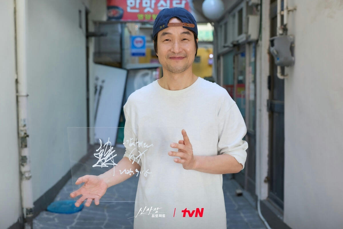 people-one man-A-holding sign-A-smiling-A-outdoor alleyway-B-Korean tv show promotion-C