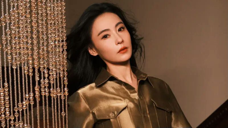 people-woman-A-dark hair-A-olive green shirt-A-beaded curtain-A-portrait