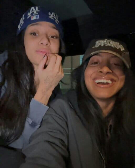 people-two women-bandana-LA Dodgers-baseball cap-smiling-dark clothing