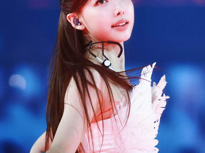 people-Nayeon (TWICE)-performer-A-feathered-costume-A-in-ear-monitor-A-white-gloves-B-dark-blue-background-C