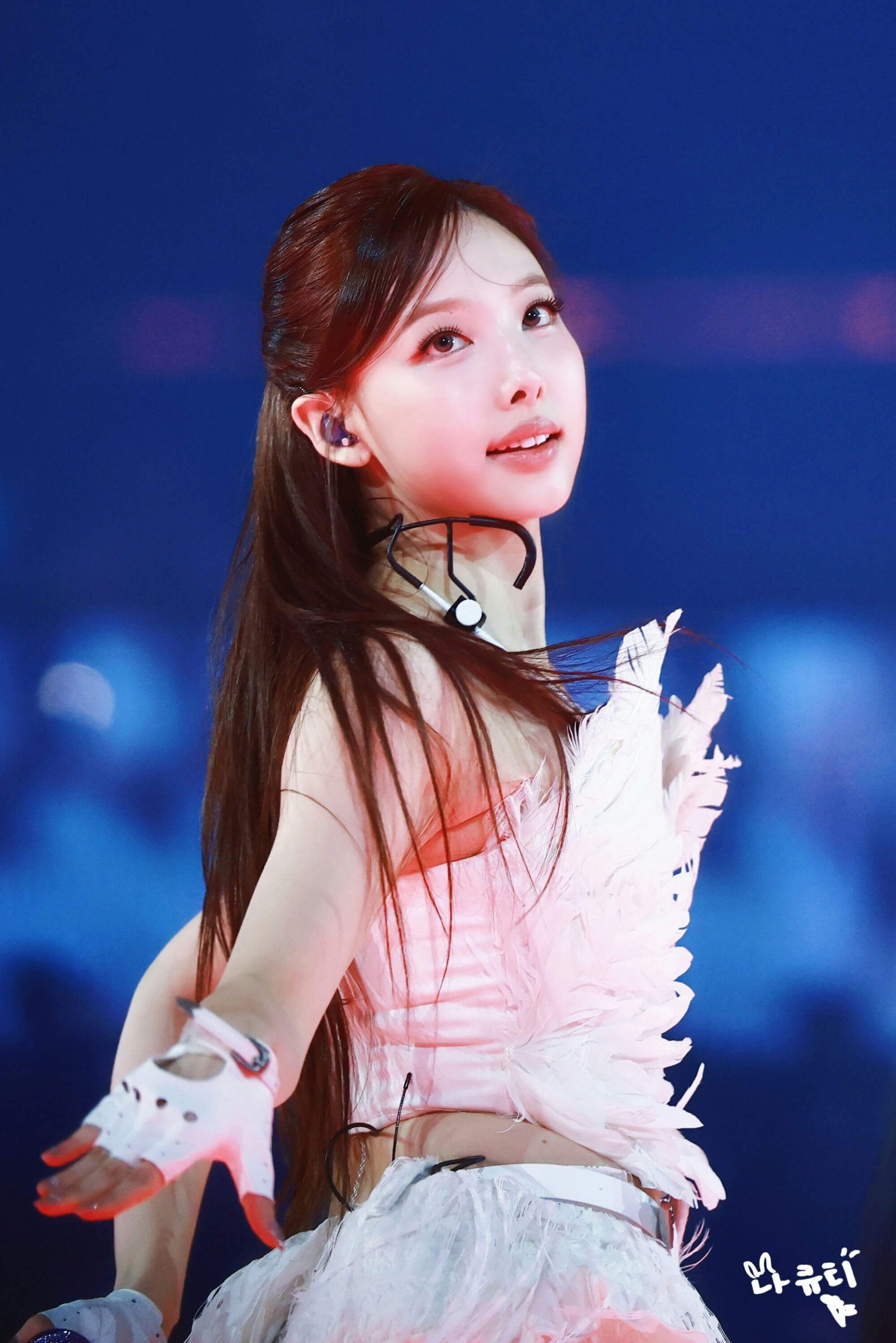 people-Nayeon (TWICE)-performer-A-feathered-costume-A-in-ear-monitor-A-white-gloves-B-dark-blue-background-C