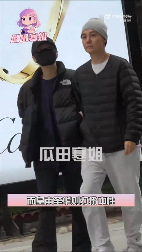 people-Two individuals outdoors-A-Person on left wearing black puffer jacket and mask-B-Person on right wearing grey beanie and black vest-C-Text overlays in Chinese characters