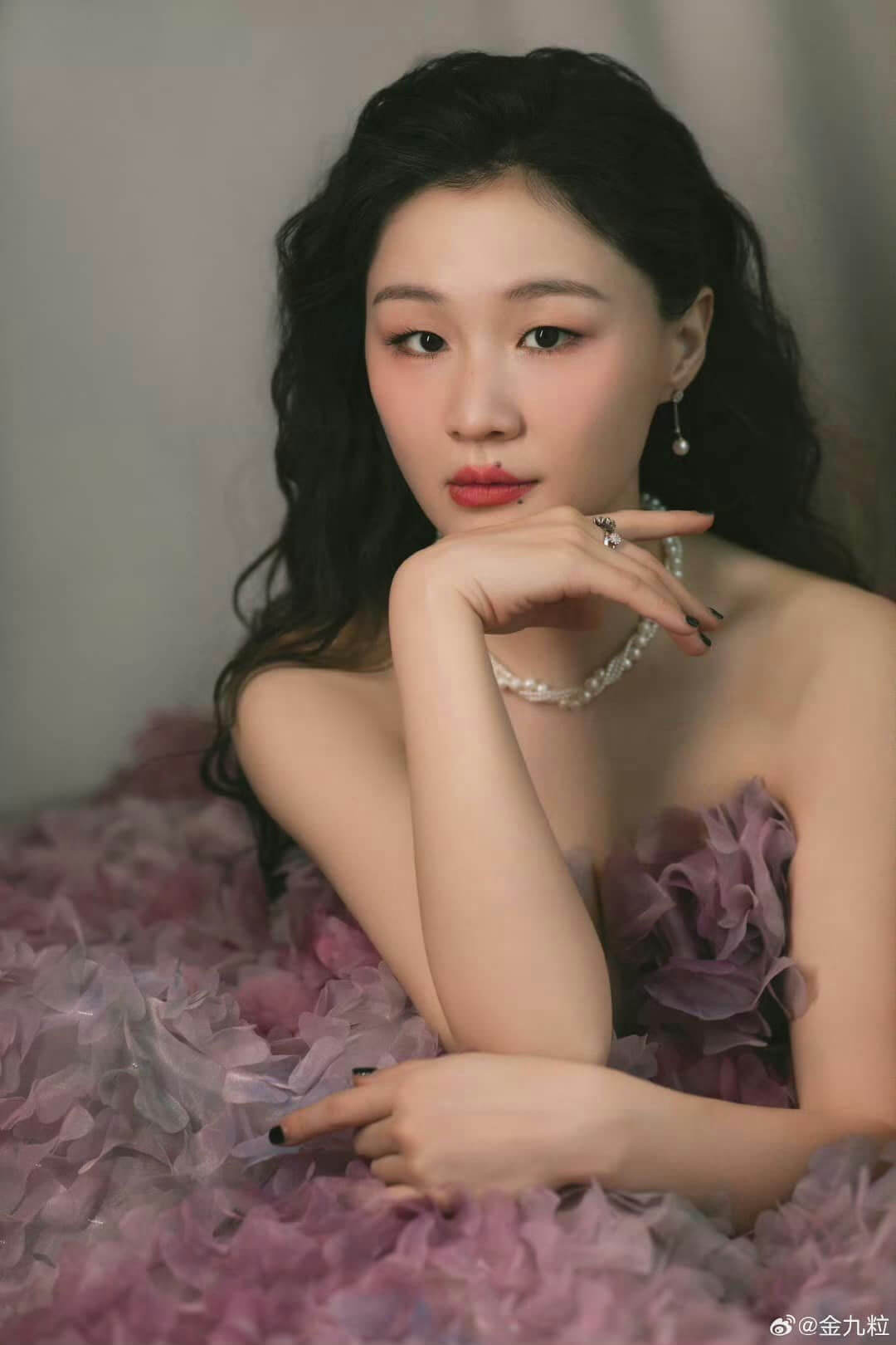 people-A-woman-A-dark hair-A-pearl jewelry-A-purple gown