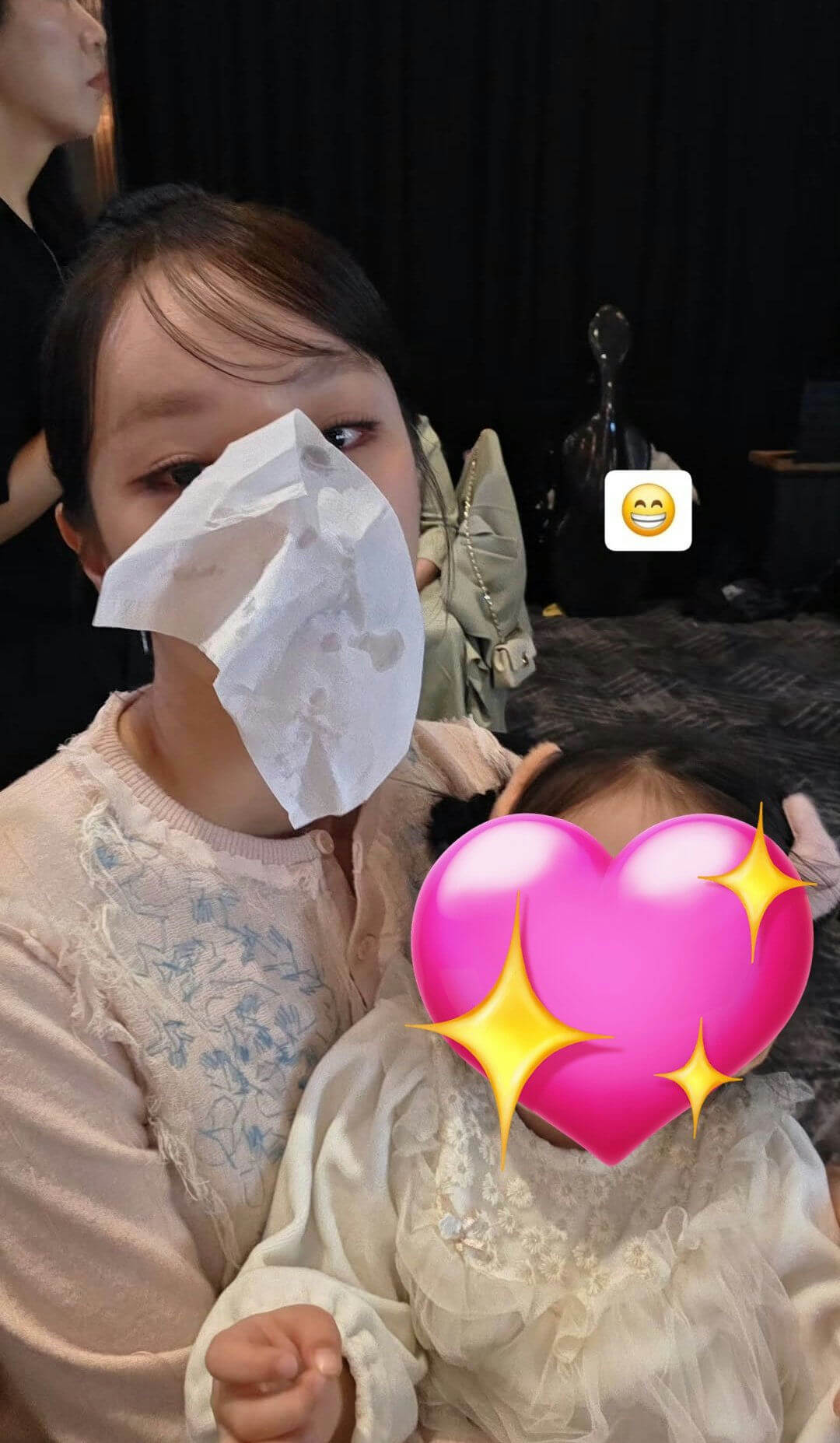 people-A-woman-A-holding-a-baby-B-wiping-her-face-with-a-tissue-C-emojis-covering-face
