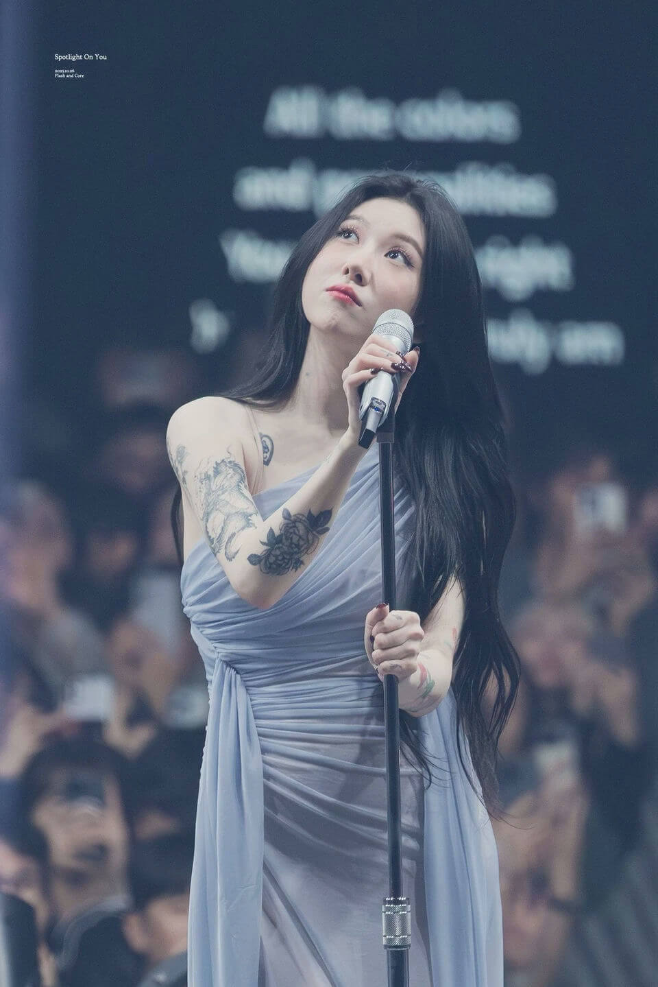 people-woman-A-singer-A-stage-A-tattooed-B-blue dress-B-holding microphone-C