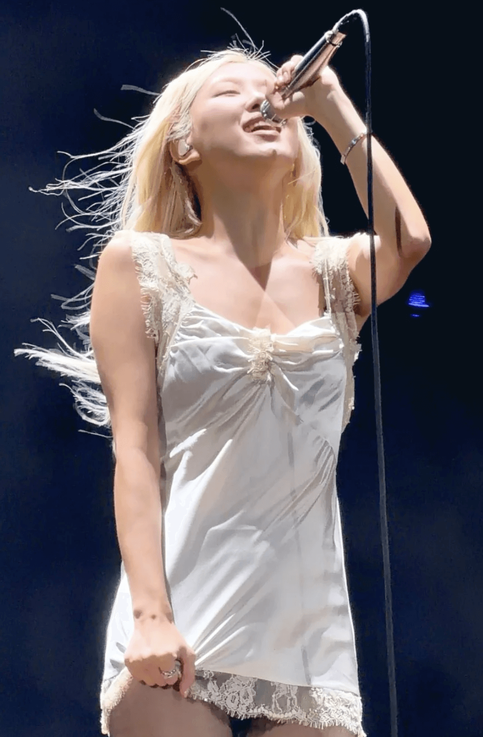 people-1-female singer-A-blonde hair-A-white lace slip dress-A-performing on stage