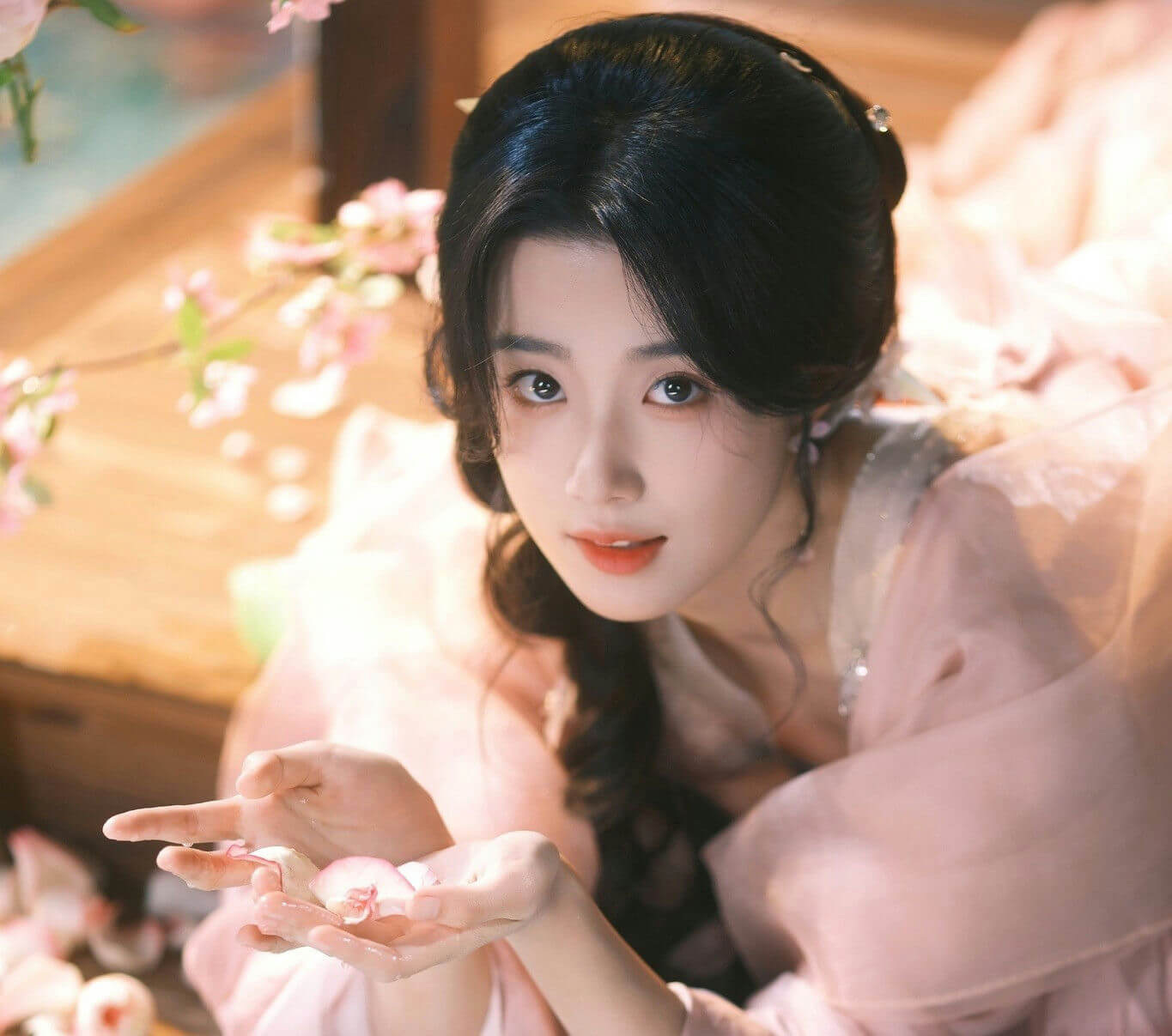 people-Asian woman-A-traditional attire-A-pink robes-B-holding petals-C-gazing forward